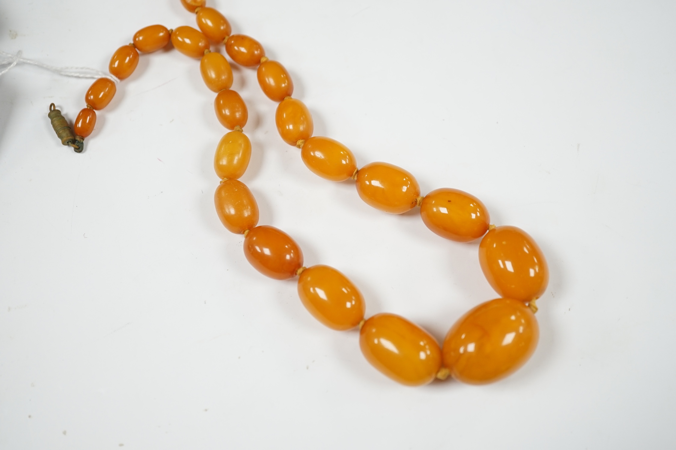 A single strand graduated oval amber bead necklace, 44cm, string broken, gross weight 39 grams. Condition - poor